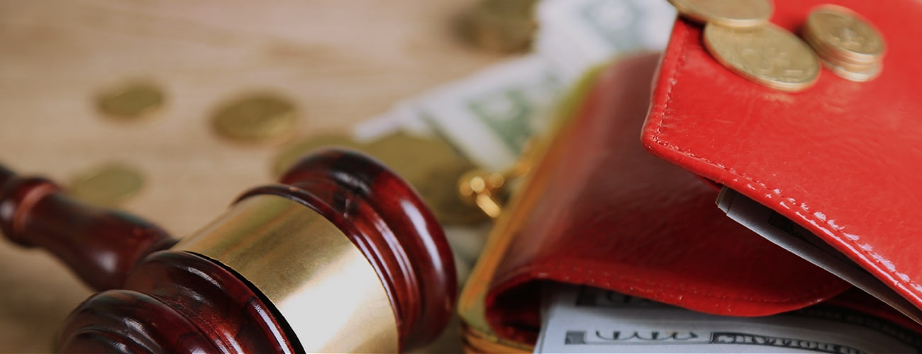 Gavel and money coins on wooden background