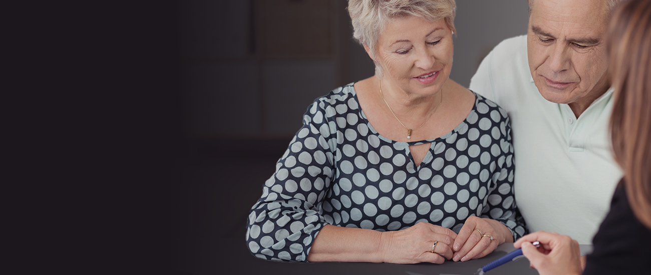 Middle Aged Couple Discussing What is on the Document at the Table
